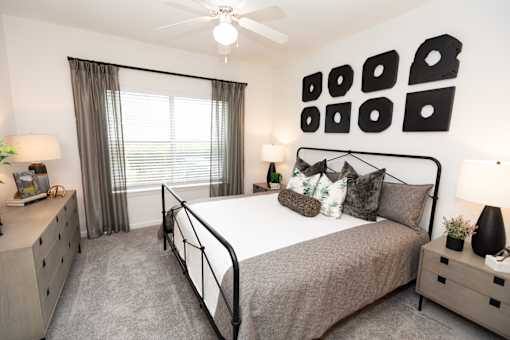 A bedroom with a bed, nightstands, and a ceiling fan.