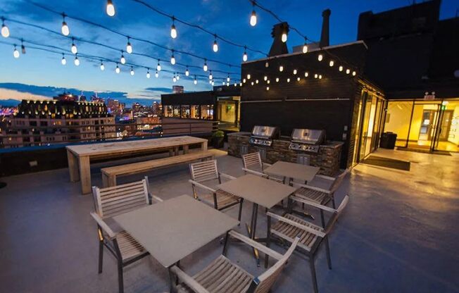 Evening rooftop dining with string lights at Archer Tower in Denver, CO