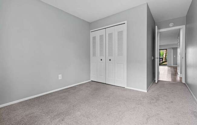 A room with a white door and carpeted floor.