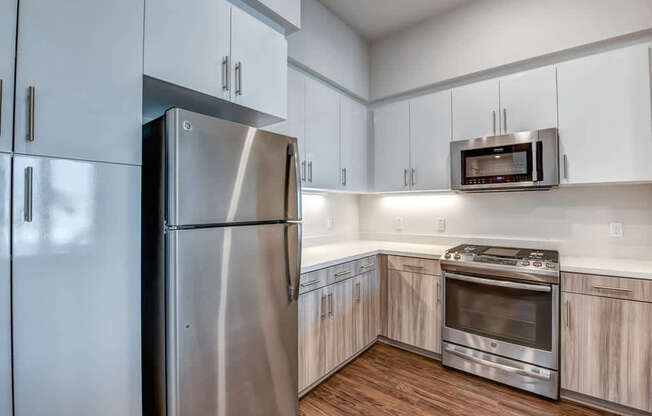 A modern kitchen with a stainless steel refrigerator and oven.