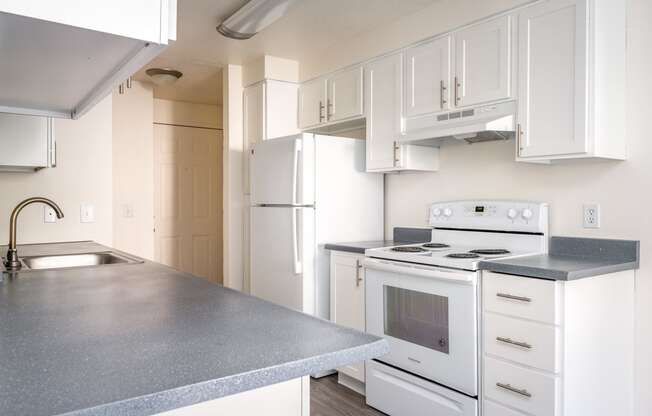 a kitchen with white cabinets and white appliances