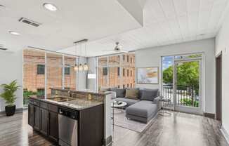 a living room with a kitchen and a sliding glass door