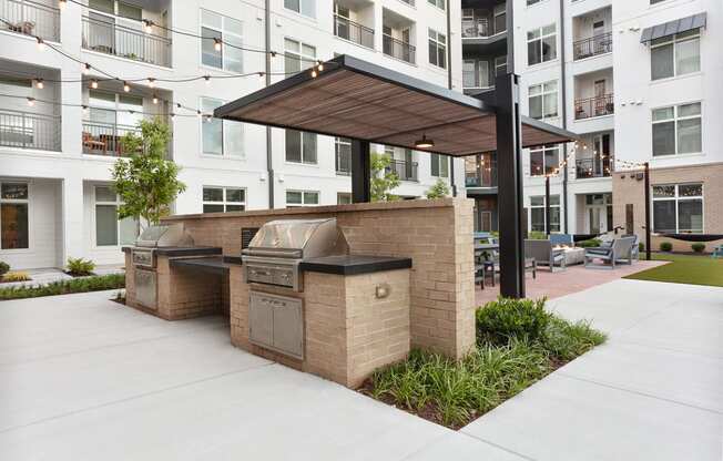 a bbq area with an apartment building in the background