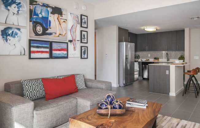 a living room with a couch and a coffee table and a kitchen