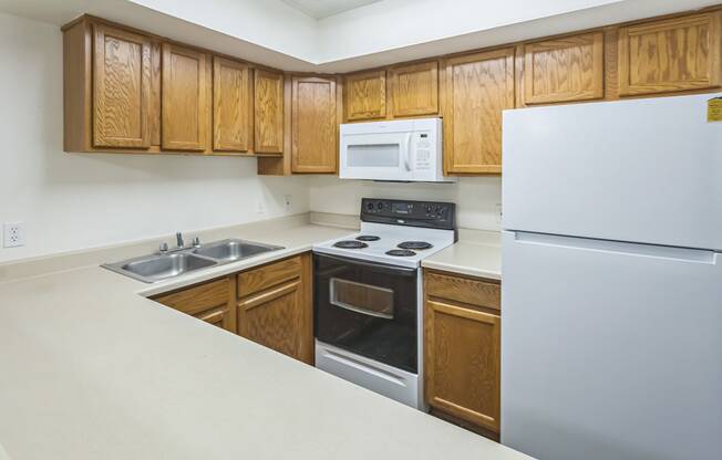 a kitchen with white appliances and wooden cabinets