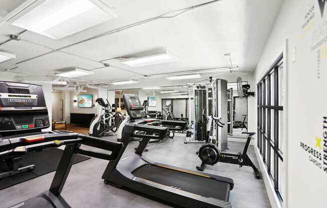 A gym with treadmills, exercise bikes and other equipment.