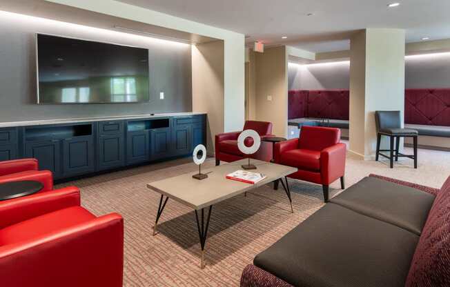 a living room with red chairs and a table