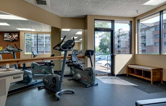 Fitness room with various equipment and a large mirror wall