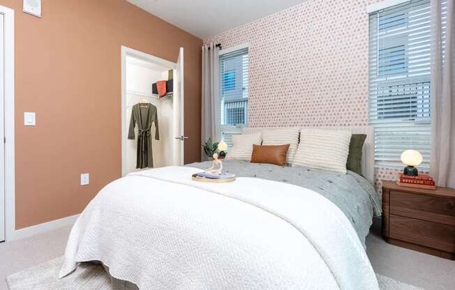 A bedroom with a large bed and a window with blinds.