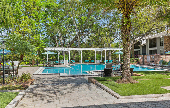 Community Swimming Pool with Pool Furniture at Grand Pavilion Apartments in Tampa, FL.