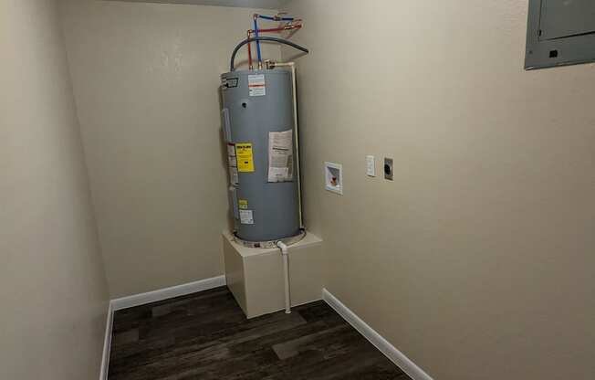 a room with a water heater in the corner