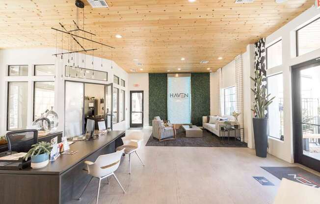 A modern office space with a reception desk and seating area.