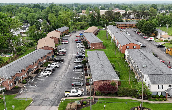 A parking lot in front of a building with a grassy area.