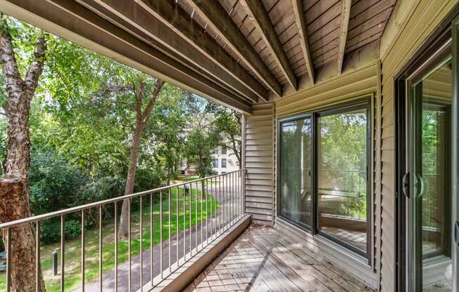 the screened in porch has a view of the yard and trees