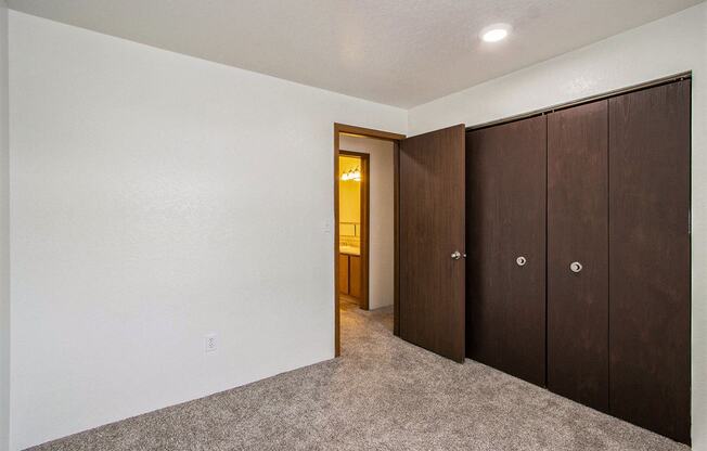a bedroom with a closet and a door to a bathroom