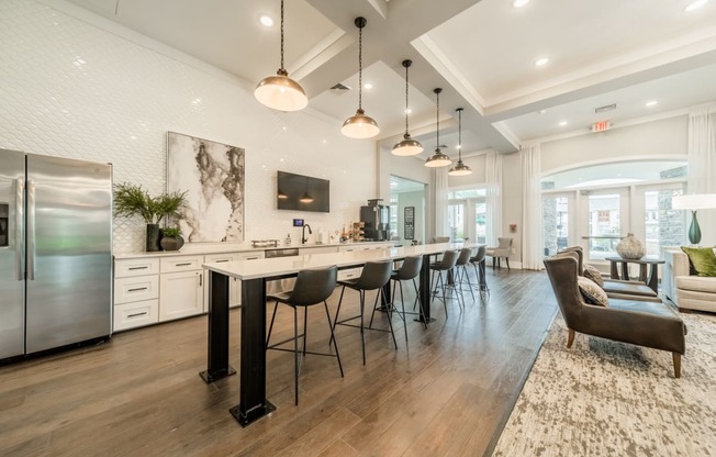 the gathering room and kitchen of a new home with a large island and chairs