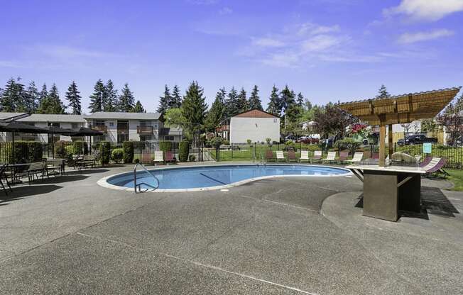 Sparkling Outdoor Pool and Hot Tub with Trees in the Background at Pinewood Square Apartment Homes, Lynnwood, Washington 98087