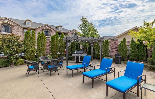 an outdoor patio with blue chairs and a gazebo