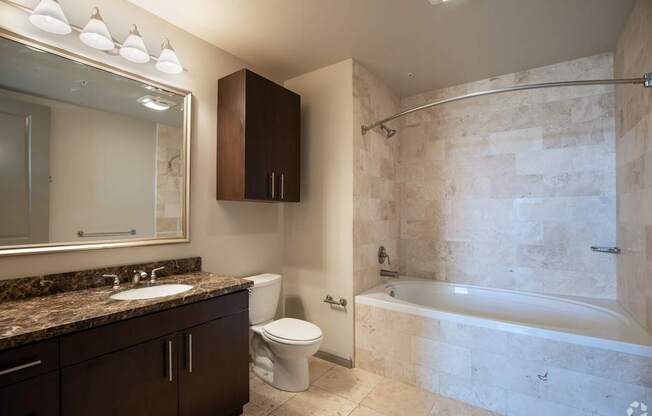 A bathroom with a marble countertop and a walk-in shower.
