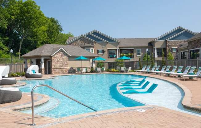 A large swimming pool with a slide and lounge chairs.