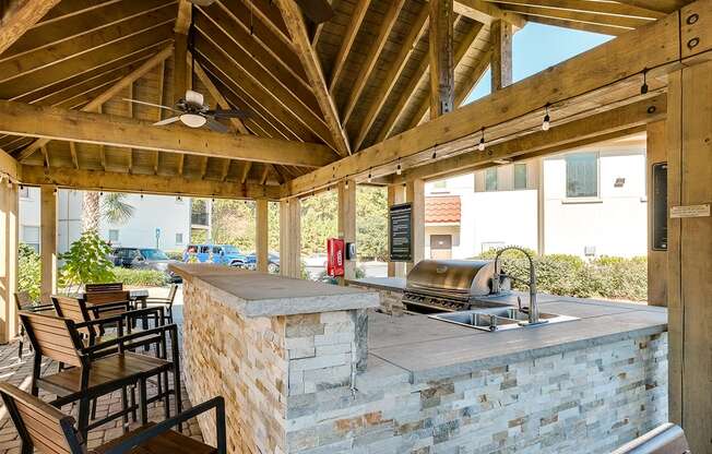 Outdoor grilling pavilion with bar counter seating at Two Addison Place Apartments , Pooler, GA