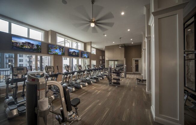 A gym with a variety of equipment including treadmills, stationary bikes, and weight machines.