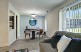 - Maple Place Apartments a living room with a couch and a table with chairs