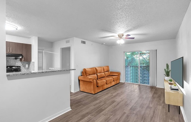 A living room with a brown couch and a flat screen TV.