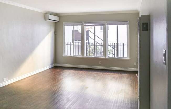 an empty living room with wood floors and a window