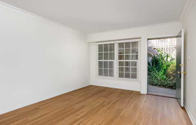 a bedroom with hardwood floors and white walls