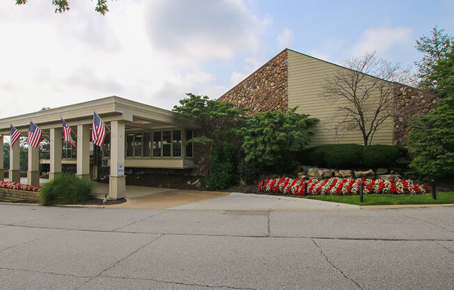 a building with flags and flowers in front of it