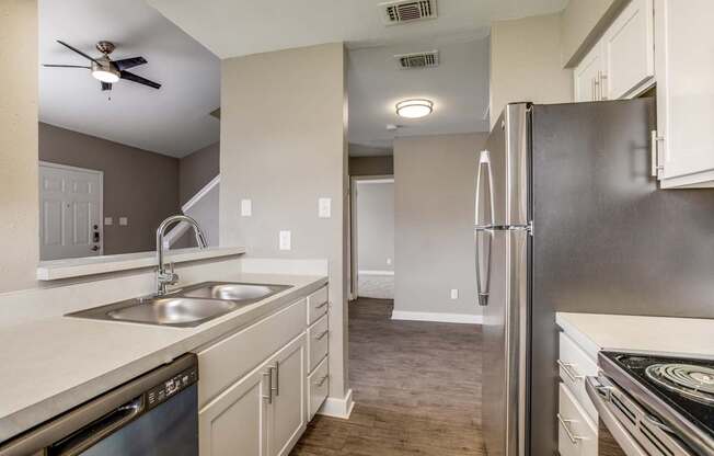 A modern kitchen with a stainless steel refrigerator and a dishwasher.