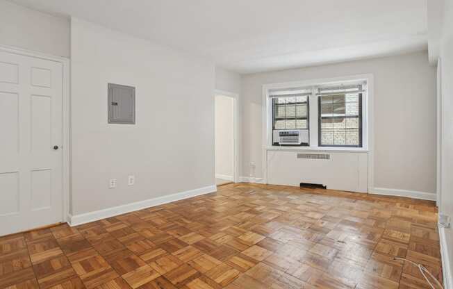 a living room with a hardwood floor and a window
