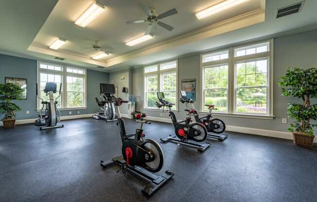 a home gym with exercise bikes and windows
