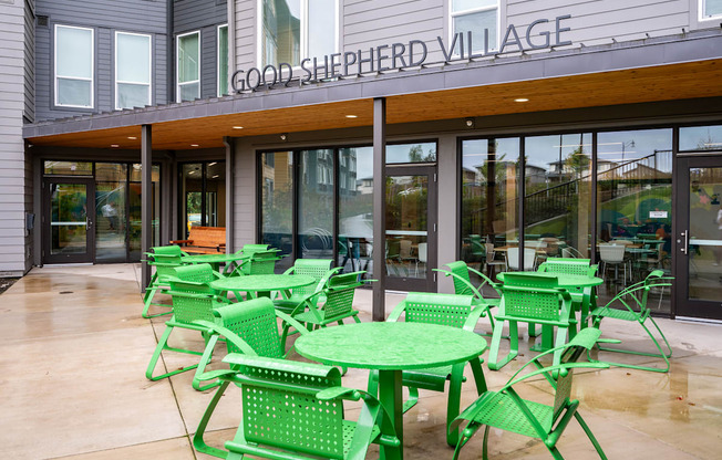 a patio with green chairs and tables outside of a restaurant