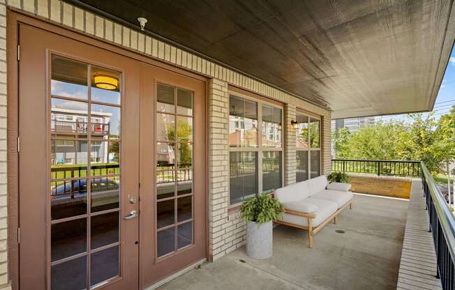 the porch of a building with a couch and a chair on it