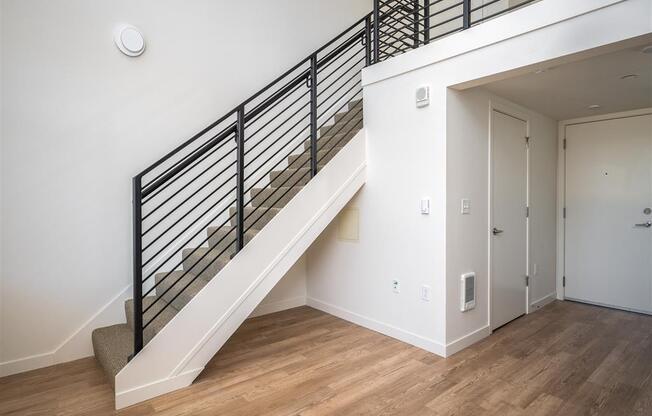 a view of a stairwell in a home with white walls and wood floors