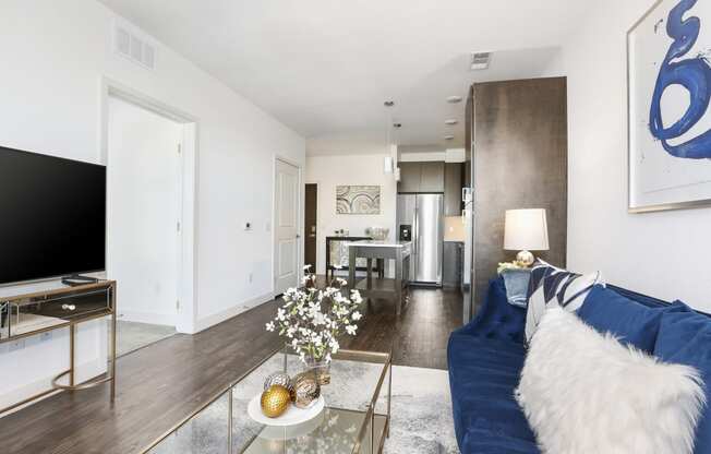 a living room with a blue couch and a glass coffee table