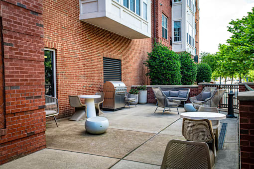 an outside patio and a grilling station at Park Square Apartments