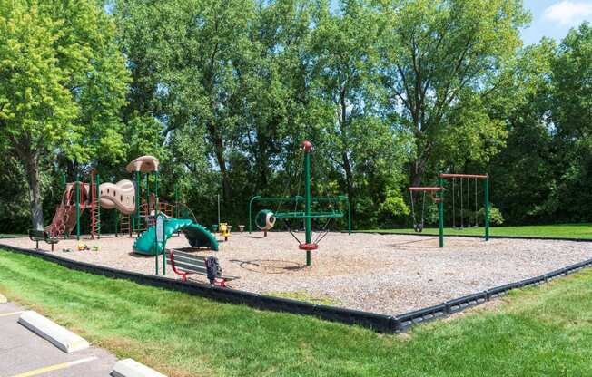a playground with a large swing set and other playground equipment in a park