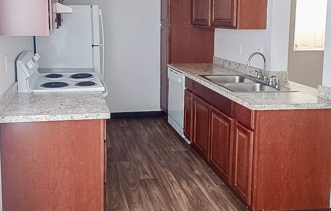 A kitchen with wooden cabinets and a white stove top oven.