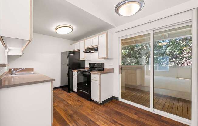 A kitchen with a refrigerator, oven, and sink at Clackamas Trails Apartments, Oregon, 97222