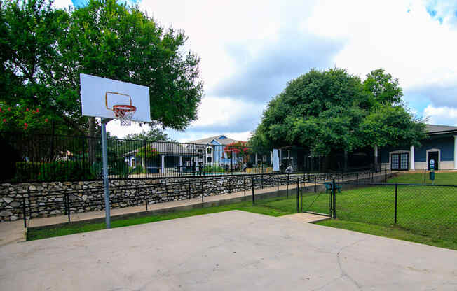 a basketball court in a park in front of houses