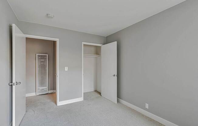 A room with two open doors and a carpeted floor.