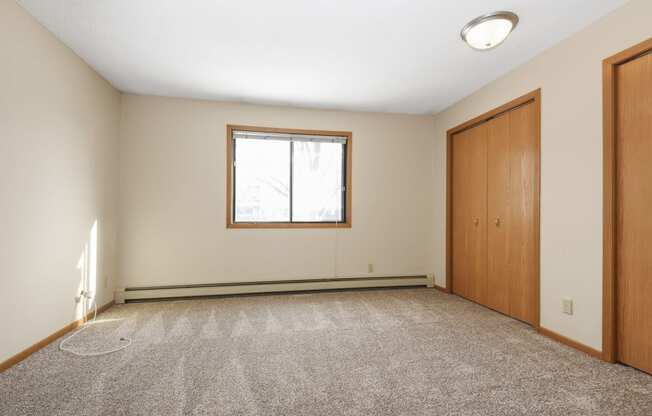 Anoka, MN Dellwood Estates Apartments. A bedroom with a window and a closet