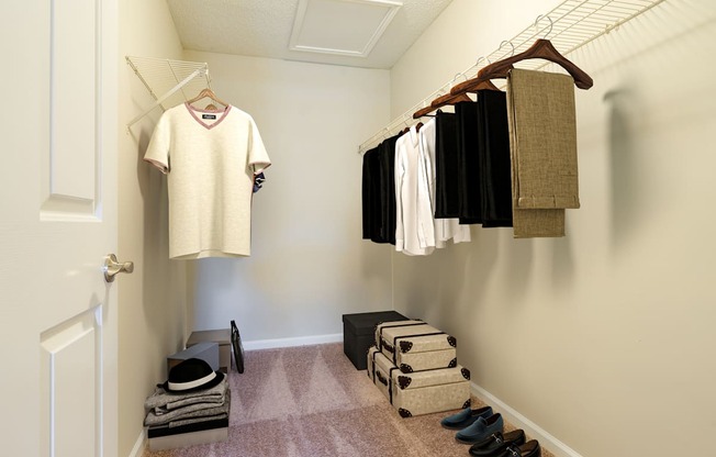 a walk in closet with clothes hanging on the wall and shoes on the floor