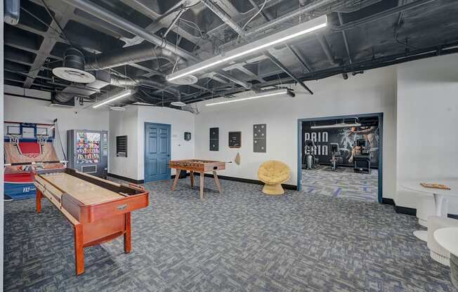 A room with a pool table and a foosball table.