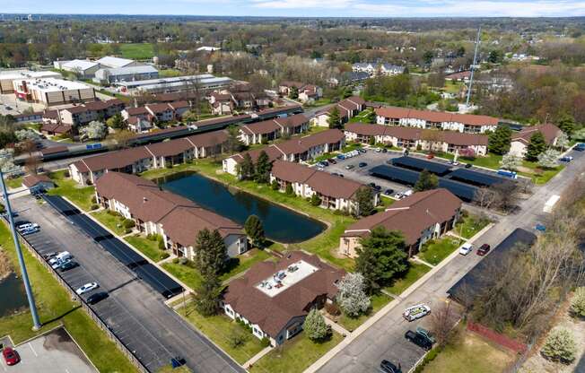 an aerial view of a neighborhood with houses and a pond