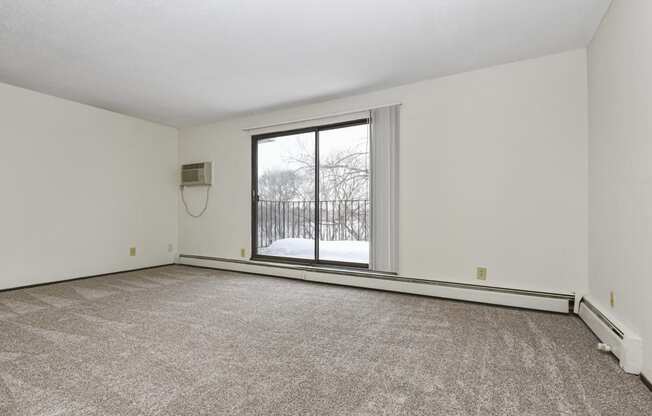 Fridley, MN Georgetown Apartment. A living room with a large window and a carpeted floor