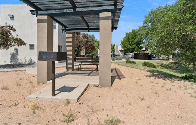 a picnic pavilion with a bench in front of a building